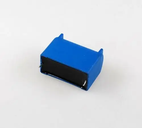 Blauer Kondensator mit zwei Anschlussbeinen. Der Kondensator ist Teil eines Ventilators von Remko, verwendet in Klimaanlagen oder ähnlichen Anwendungen.