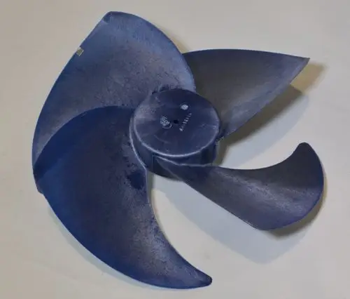 Remko Ventilatorflügel in dunkler Farbe, mit mehreren geschwungenen Klingen und einem zentralen Befestigungspunkt, auf einem neutralen Hintergrund platziert.