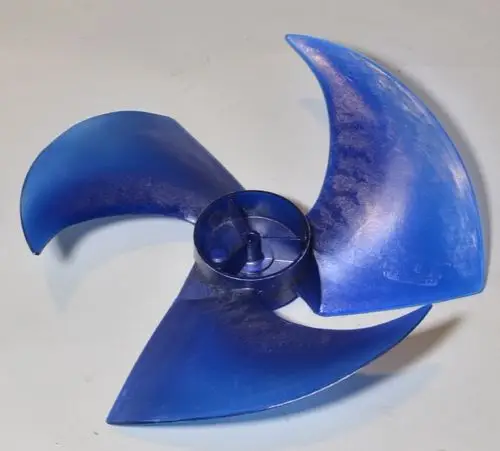 Blauer Ventilatorflügel mit drei geschwungenen Schaufeln, zentraler Montagesockel. Produkt der Marke Remko, vermutlich für einen Verflüssiger eingesetzt.