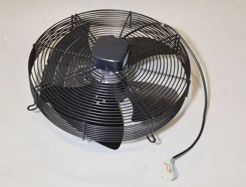 Umluftventilator mit schwarzem Metallgitter, sichtbaren Lüfterblättern und einem Kabel mit mehreren Drähten, hergestellt von Remko.