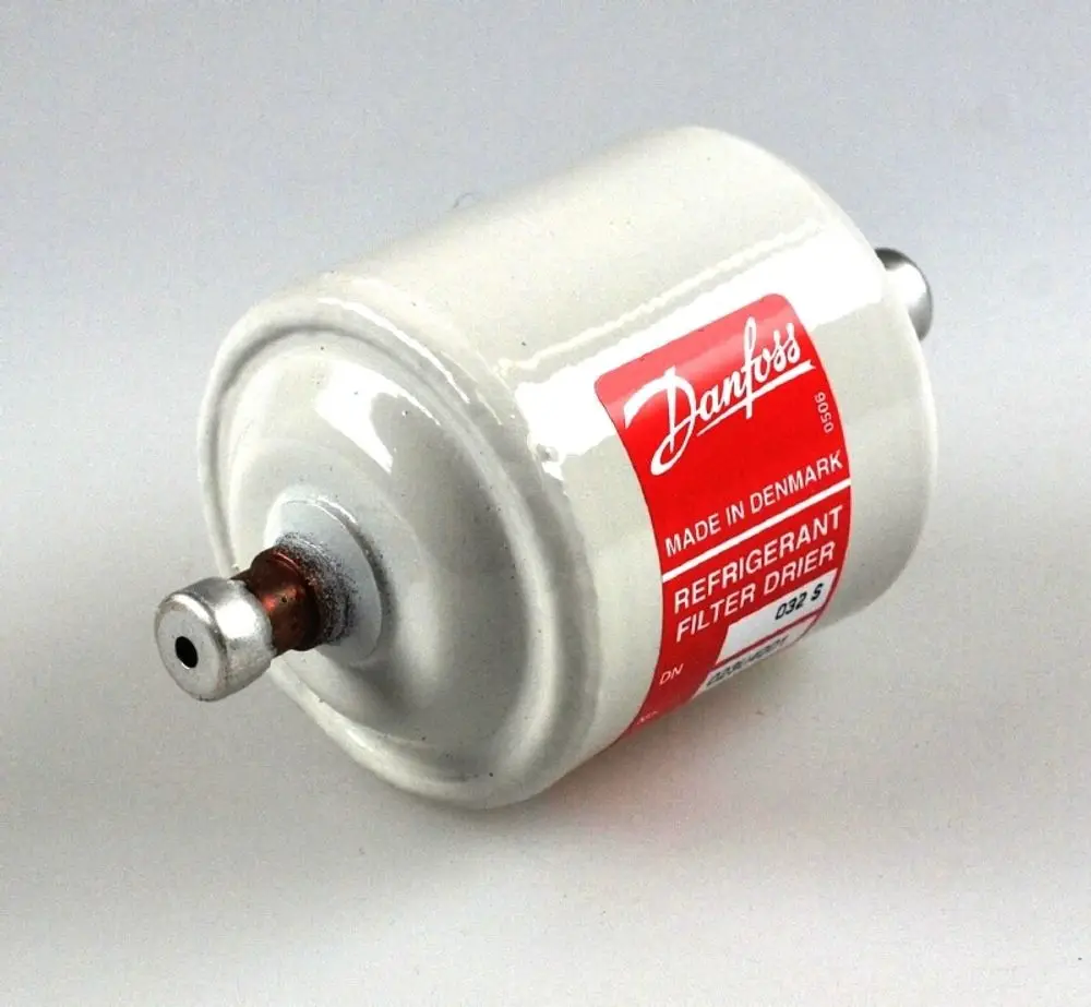 Weißer Trockenfilter mit rotem Etikett und Anschlüssen an beiden Enden, hergestellt von Remko, für den Einsatz in Kühlsystemen zur Entfernung von Feuchtigkeit und Verunreinigungen.