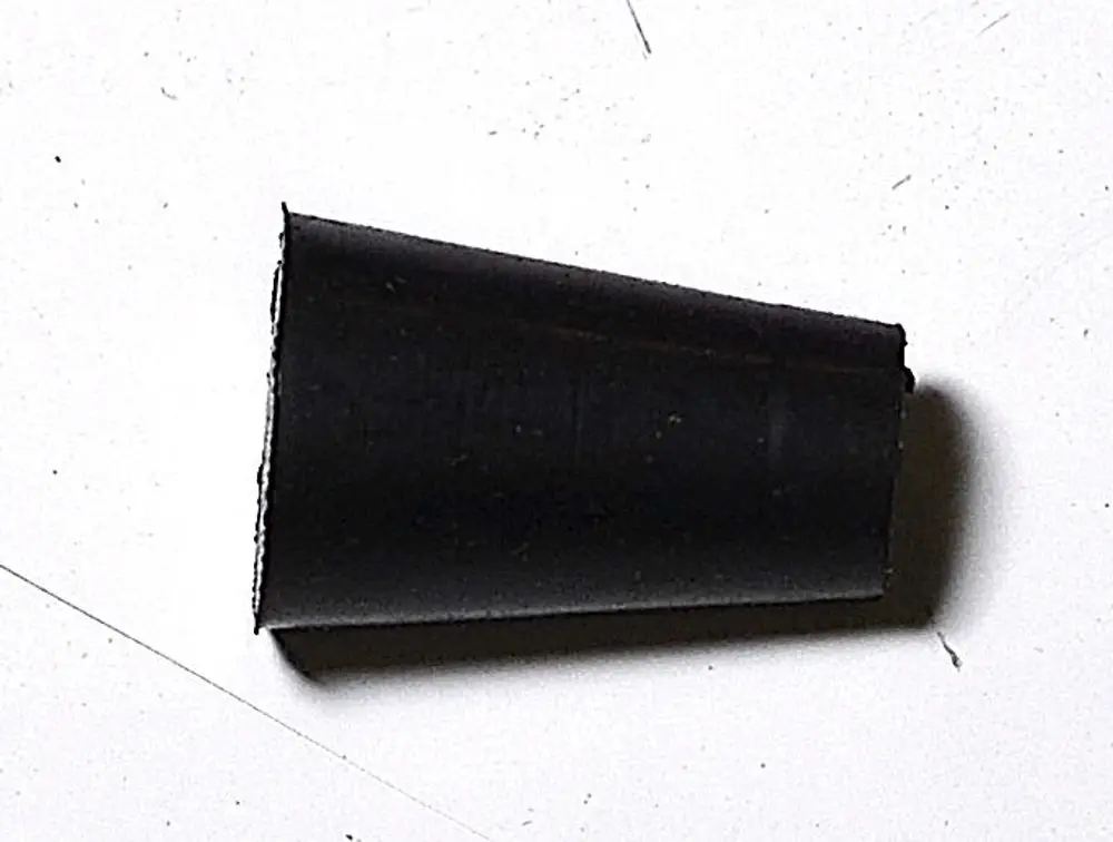Schwarzer Stopfen auf einem hellen Untergrund, gehört zur Produktpalette von Remko. Das Objekt hat eine konische Form und eine glatte Oberfläche.