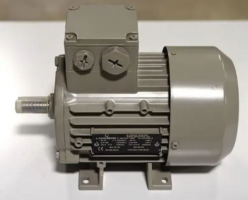 Elektromotor in grauer Farbe, ausgestattet mit einem Gehäuse und einem Anschlusskasten. Marke Remko, deutliche Kühlrippen auf der Gehäuseoberfläche.