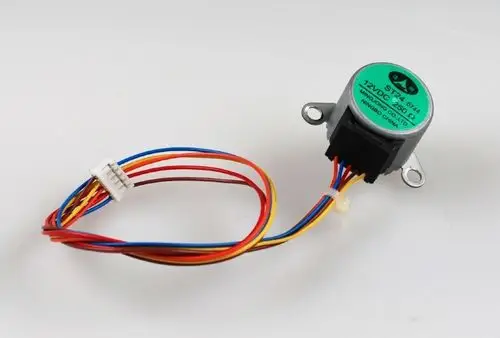 Motor mit einem grünen Aufkleber, mehreren farbigen Drähten und einem Steckverbinder. Herstellerangabe „Remko“ sichtbar.