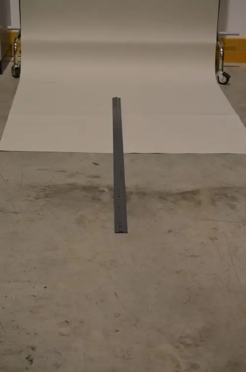 Graue Wandkonsole auf einem Betonboden, mit einer hellen Fotopapierunterlage im Hintergrund. Geeignet für feste Montagen, Marke Remko.