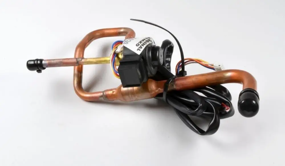 Elektronisches Teil mit Kupferleitungen und einem schwarzen Gehäuse, typischerweise für Klimaanlagen oder Kühlgeräte, erkennbar als Produkt von Remko.