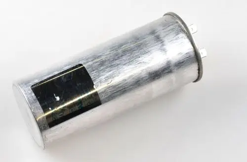 Metallischer Kondensator mit zwei Anschlussklemmen. Die Oberfläche ist glänzend und zeigt leichte Gebrauchsspuren. Hersteller: Remko.