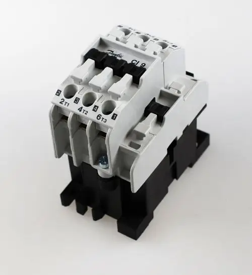 Schaltschütz der Marke Remko, mit mehreren Anschlüssen und einer 230V-Spule, auf einem weißen Hintergrund.