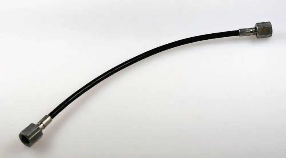 Schwarze Öldruckleitung mit zwei Metallanschlüssen, hergestellt von Remko. Die Leitung hat eine gebogene Form und wird zur Verbindung von Komponenten verwendet.
