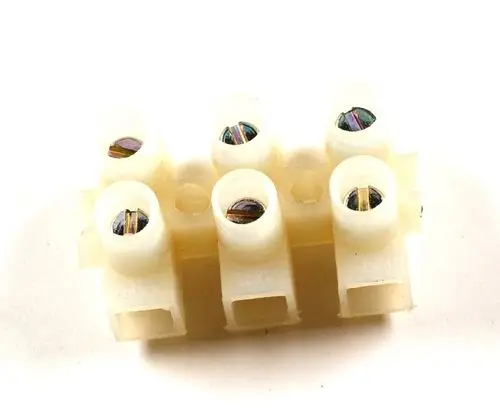 Bodenmontierte Klemmleiste von Remko mit mehreren Anschlussklemmen, die für elektrische Verbindungen verwendet wird. Sichtbare Schraublöcher zur Befestigung von Drähten.