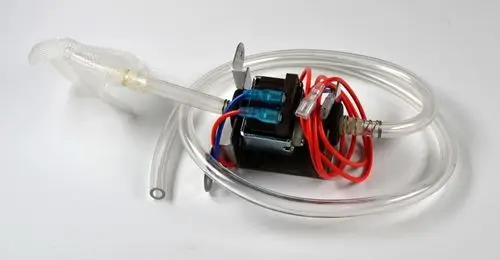 Kondensatpumpe mit transparenten Schläuchen und elektrischen Anschlüssen. An der Pumpe sind Kabel in Rot und Blau zu sehen. Hersteller Remko.