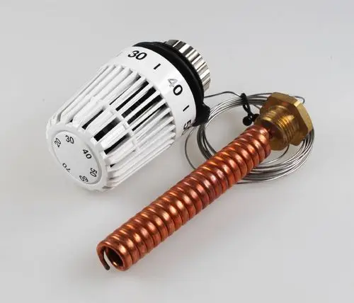 Mischventiloberteil aus Metall mit weißen Kunststoffteilen und Skala, kombiniert mit einem kupferfarbenen Rohr. Produkt von Remko für Heizungsanwendungen.