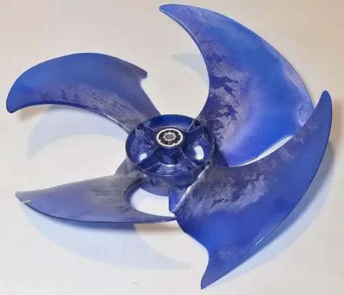 Blauer Ventilatorflügel mit vier geschwungenen Blättern, montiert auf einer zentralen Achse, verwendet in einem Remko-Verflüssiger.