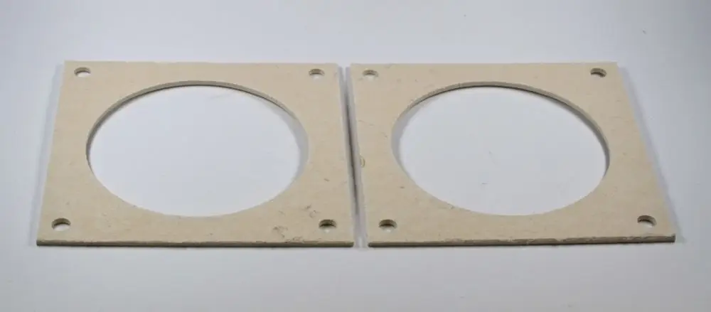 Zwei gleichformatige Dichtungen aus einer hellen Materialoase mit kreisförmigen Ausschnitten und vorgebohrten Löchern, geeignet für Remko Brennkammerflansche.