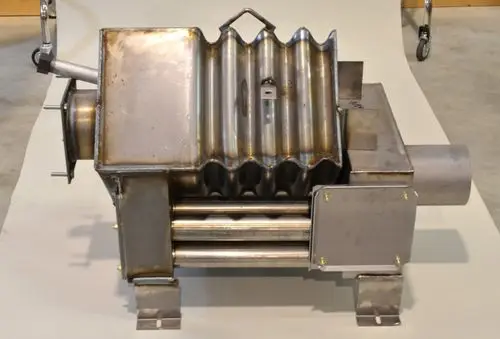 Edelstahl-Brennkammer von Remko mit gewellter Oberfläche und seitlichem Anschluss, montiert auf einem stabilen Gestell, aus mehreren Metallteilen gefertigt.
