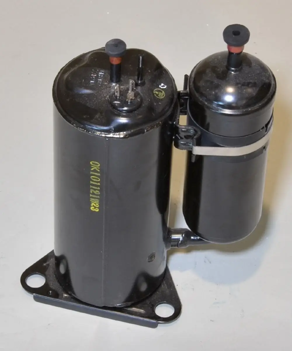 Zwei schwarze Kompressoren mit Elektroanschlüssen, verbunden durch einen Schlauch, montiert auf schwarzem Sockel. Produkt von Remko.