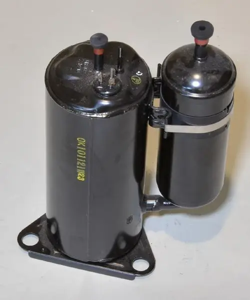 Zwei schwarze Kompressoren mit Elektroanschlüssen, verbunden durch einen Schlauch, montiert auf schwarzem Sockel. Produkt von Remko.