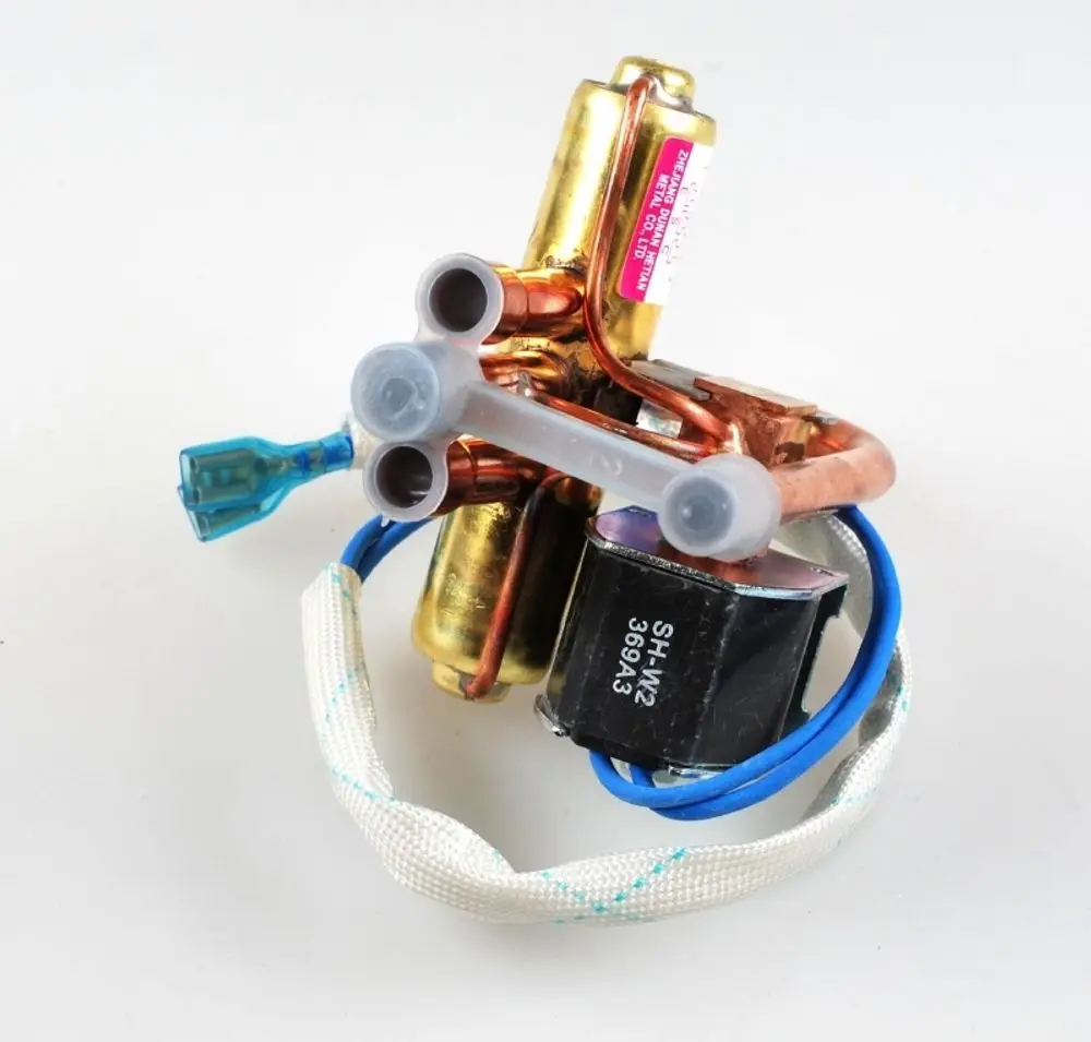 Umkehrventil von Remko mit Metallrohren, elektrischen Anschlüssen und einer schwarzen Komponente. Das Produkt zeigt diverse Verbindungselemente und Kabel.