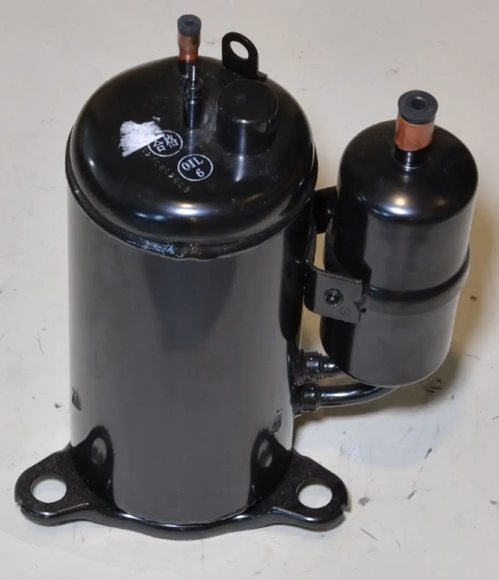 Schwarzer Kompressor mit zwei Anschlüssen, montiert auf einer Basisplatte. Produkt stammt von der Marke Remko.