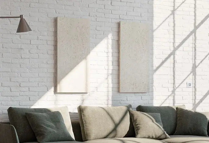 Helle Wand mit zwei montierten Heizpaneelen und einer Sofa-Garnitur in neutralen Farben. Eine moderne Dimplex-Heizung ist sichtbar, mit Licht- und Schatteneffekten im Raum.