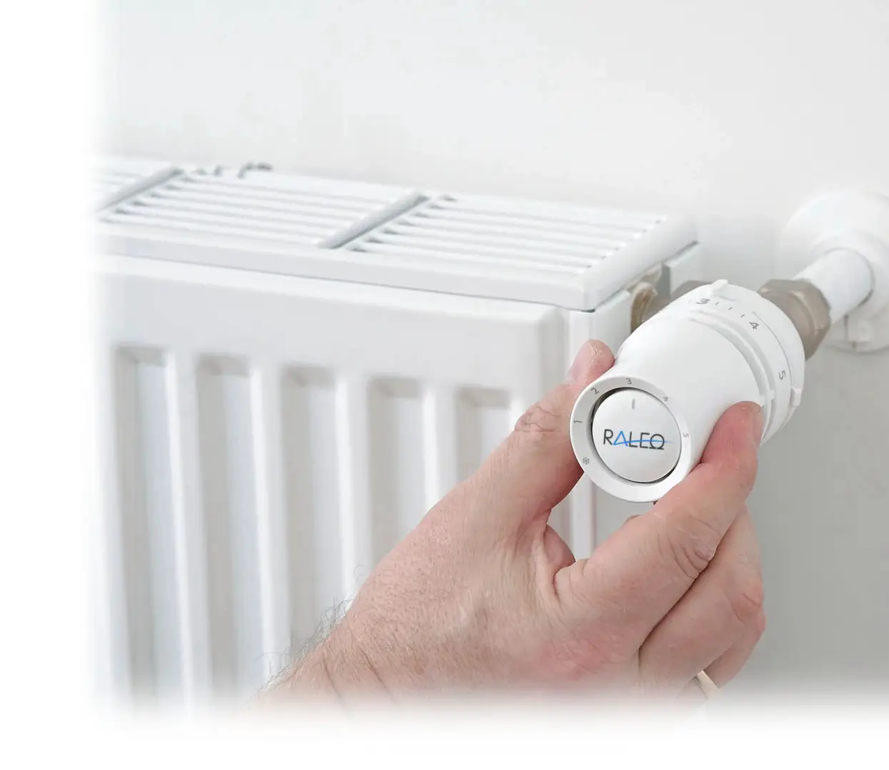 Weißer Thermostatkopf mit Skala zur Temperatureinstellung, montiert an einem Heizkörper. Der Heizkörper ist vertikal und zeigt ein schlichtes Design.