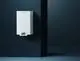 Weißes Wandgerät von Brötje mit digitalem Display und Bedienelementen, installiert in einem modernen Raum mit dunkler Wand.