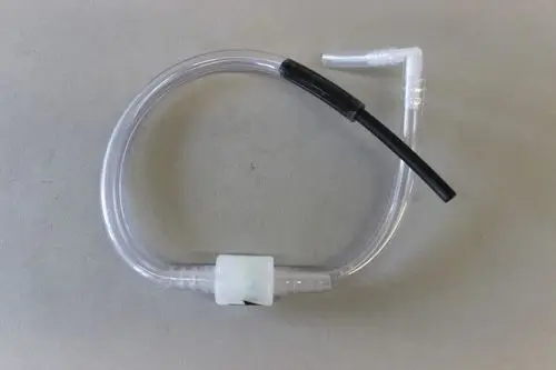 Transparenter Schlauch mit Anschlussstücken, verwendet in Heizungsanlagen, möglicherweise von der Marke Brötje, auf grauem Hintergrund.