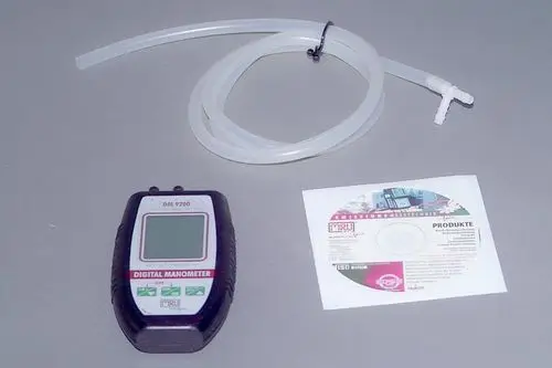 Digitalmanometer von Brötje mit zugehörigem Schlauch und CD. Gerät zur Druckmessung, abgebildet auf grauem Hintergrund.