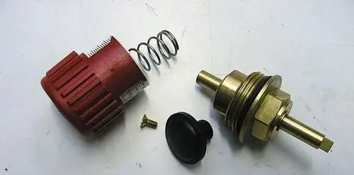 Oberteil eines Adaptersets, bestehend aus einem roten Drehknopf, einer Feder, einem Messingelement und einer schwarzen Abdeckung, hergestellt von Brötje.