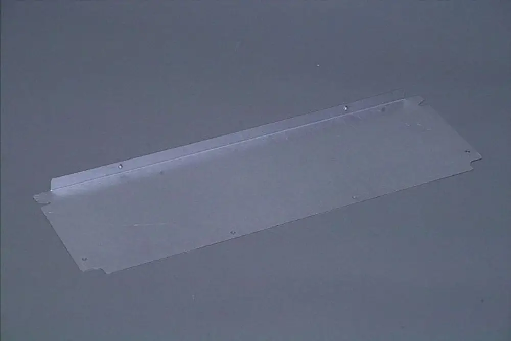 Transparente Abdeckung oder Blende mit vier Befestigungslöchern, möglicherweise von Brötje, auf grauem Hintergrund.