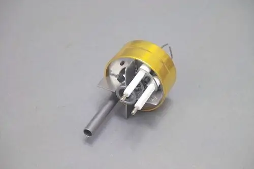 Mischkopf mit runder Metallbasis, zwei weiße Zuleitungen und einem Seitenrohr. Teil eines Heizungssystems, möglicherweise von der Marke Brötje.