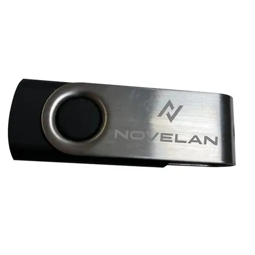 USB-Stick mit einem Metall-Clip, auf dem der Schriftzug „NOVELAN“ in grauer Schrift zu sehen ist. Der Clip hat eine schwarze Gummioberfläche.