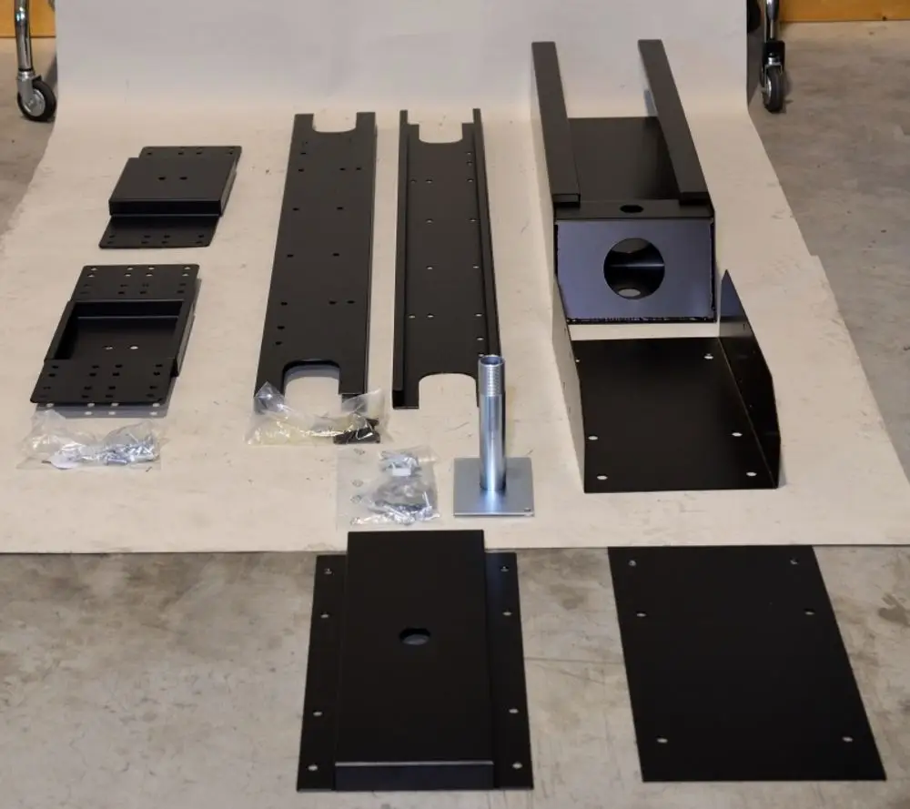 Auf einem Tisch liegen die Einzelteile für eine Remko RK Konsole zur Wandmontage (drehbar, GPM 55, 228762) aus Metall.