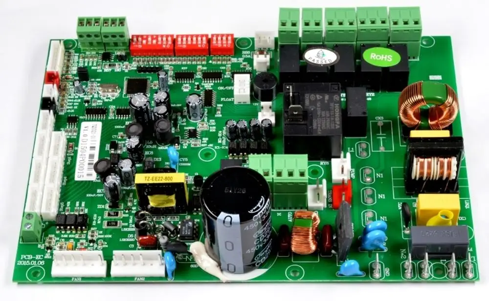 Eine grüne Remko RK Steuerplatine KWD 70 EC (1106796) mit elektronischen Bauteilen, Anschlüssen und Etiketten, die auf einer weißen Oberfläche liegt.