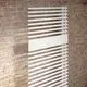 Freistehender weißer Kermi Credo Half Round Elektroheizkörper an einer Ziegelwand.
