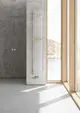 Kermi Bad- und Wohnheizkörper Pio plus in Weiß mit Holzhandtuchbügel vor Betonwand und Fenster.