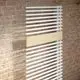 Kermi Credo Elektroheizkörper, weiß/Holz, 1800x600 mm vor Backsteinwand.