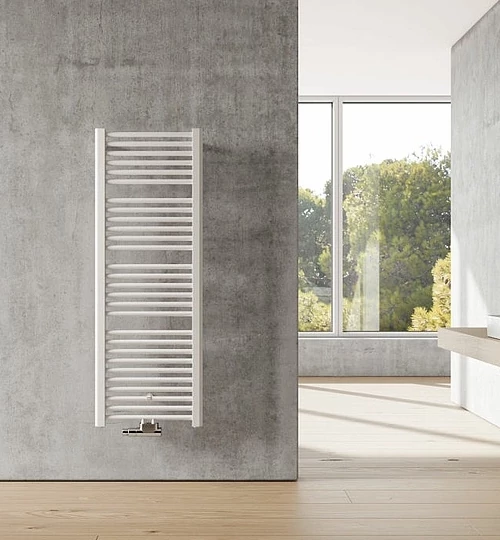 Weißer Badheizkörper mit dekorativen horizontalen Riegeln, an einer blauen Wand montiert, mit einem weißen Handtuch darauf. Modernes Badezimmer-Design.