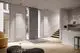 Heller Raum mit Design-Heizkörpern von Kermi, Pio, in Weiß an Betonwänden, ergänzt durch moderne Möbel und Treppe.