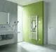 Ein Badezimmer mit einem Kermi Bad- und Wohnheizkörper Basic-E an einer grünen Wand, Handtuch darauf, neben einem Fenster mit Jalousien.