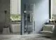Ein Badezimmer mit einem weißen Bad- und Wohnheizkörper von Kermi an einer blauen Wand, einem weißen Sessel, einer Badewanne und einem Fenster mit Jalousien.