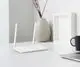 Weißer Router mit zwei Antennen auf einem Schreibtisch, neben einem Laptop und einer Tasse. Im Hintergrund eine Vase und ein Bilderrahmen. Produkt von Hoymiles.