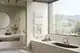 Modernes Badezimmer mit weißem Kermi Credo Half flat Heizkörper, Handtuch und Blick aus dem Fenster auf grüne Hügellandschaft.