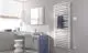 Badezimmer mit weißem Kermi Geneo quadris-E Heizkörper an grauer Wand, Handtuch, Waschtisch mit Spiegel und Hocker.